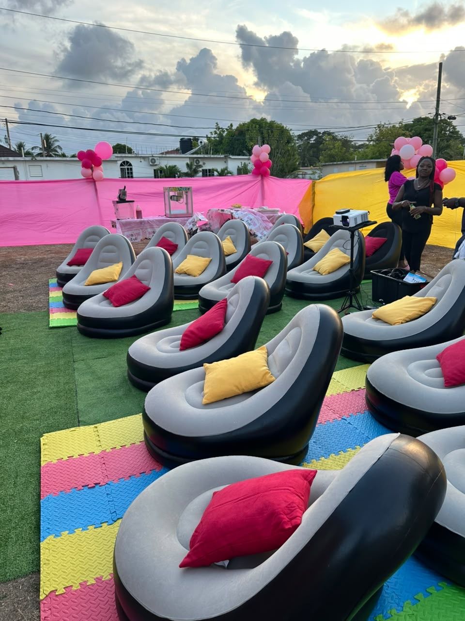 Birthday outdoor cinema setup in Jamaica with pink decor, balloons and inflatable seating