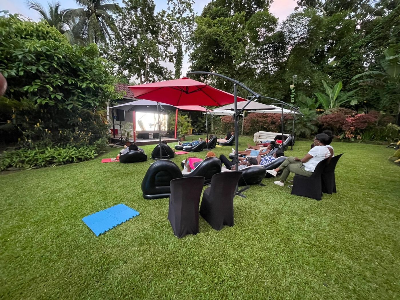Corporate outdoor movie night in Jamaica with staff seated on a lawn for a private screening