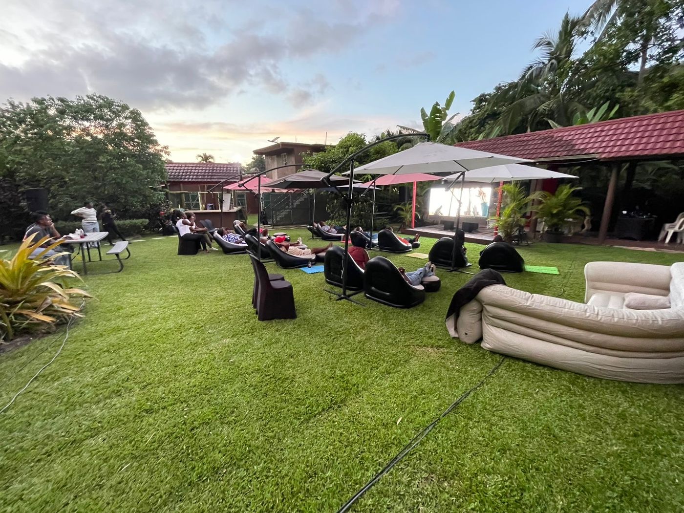 Large group community outdoor movie night on a lawn in Jamaica